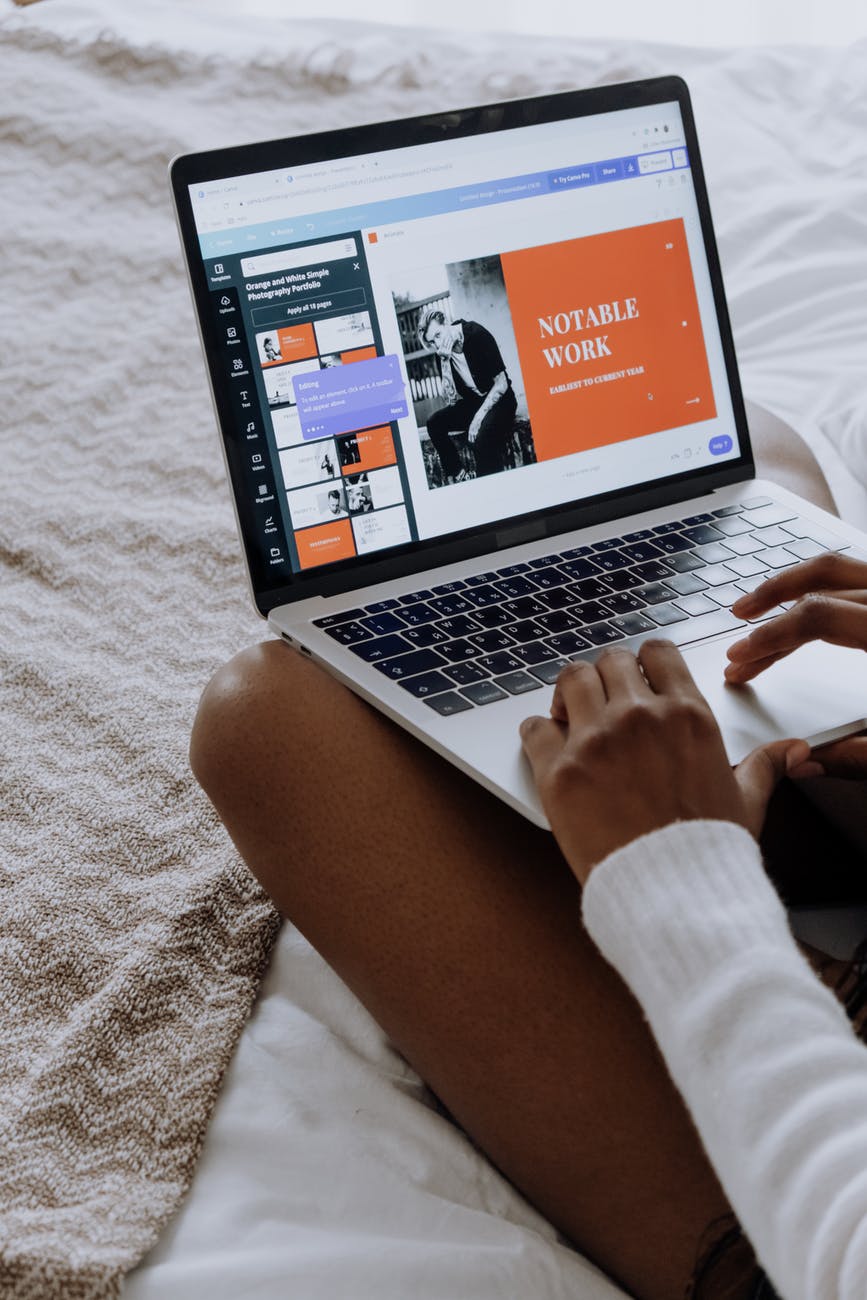 person using macbook pro on white textile